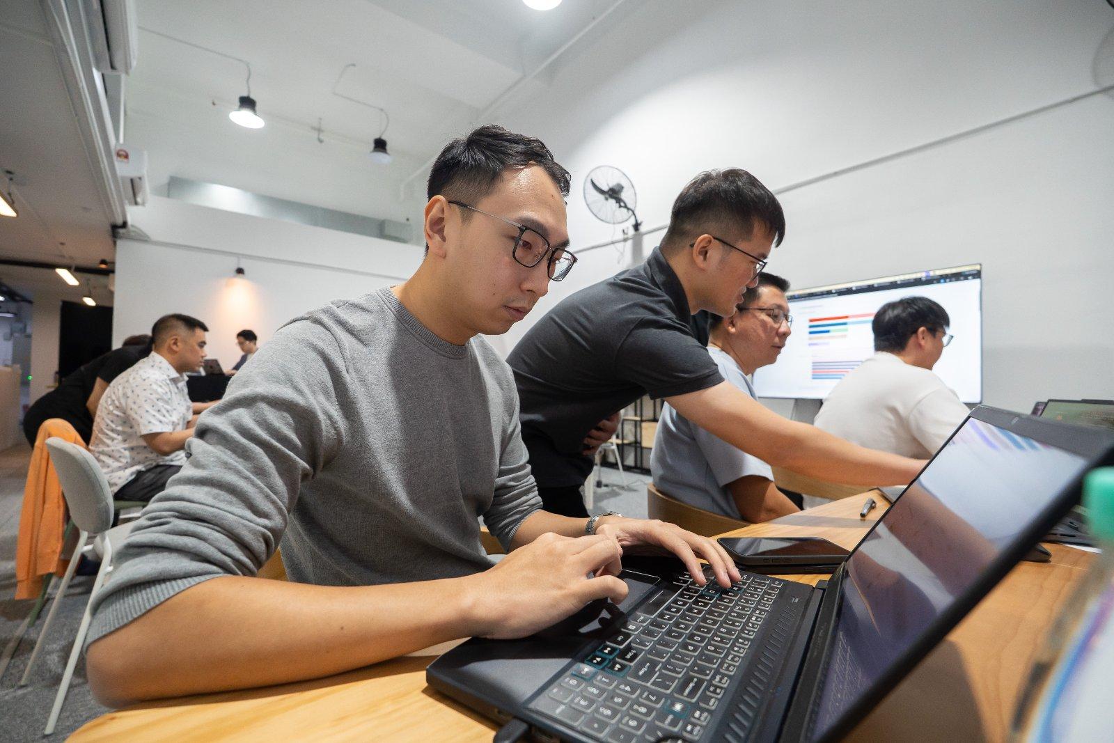 Two attendees working at their laptops