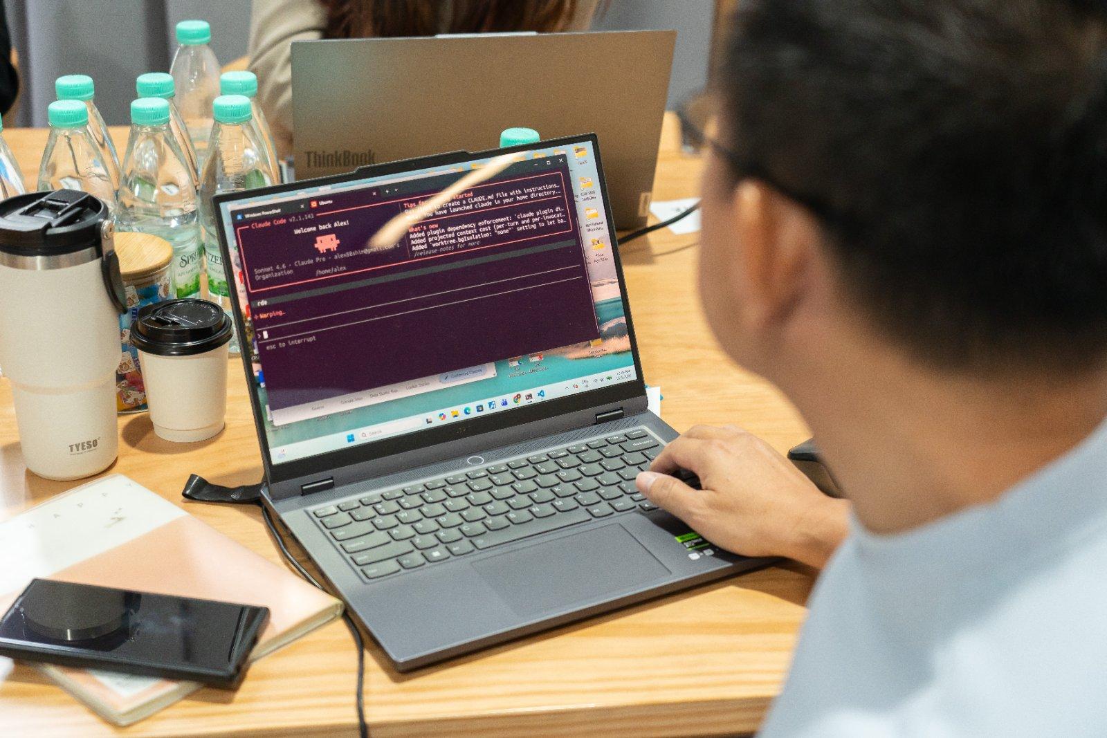 Attendee running Claude Code on a laptop