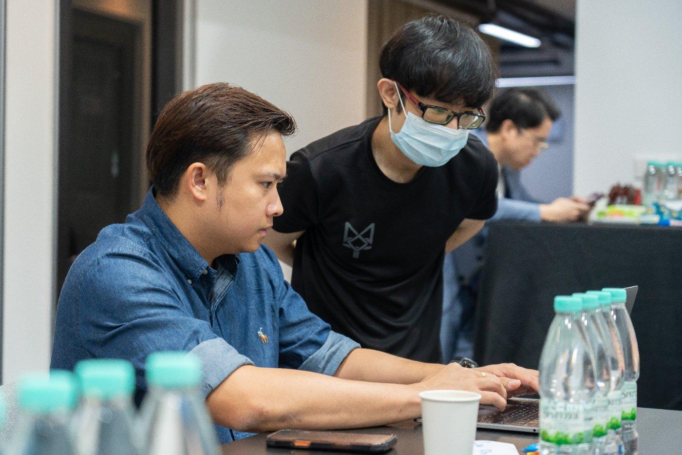 Trainer helping an attendee through their code
